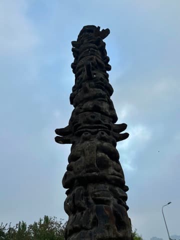Carved pole against a grey sky, Original